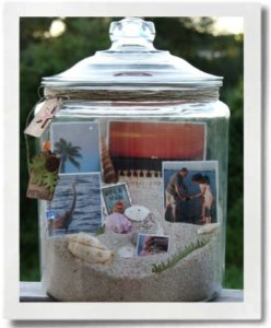 A glass jug, some sand, shells and postcards can capture a vacation in a jar!