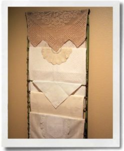 Use a repurposed crib rail or ladder to display vintage linens and doilies.